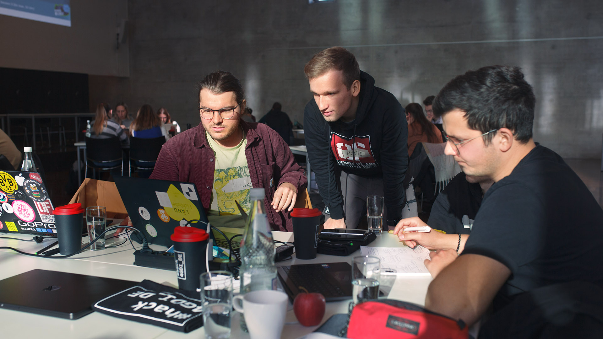 Studierende arbeiten gemeinsam an einer Aufgabe beim hack4GDI_DE