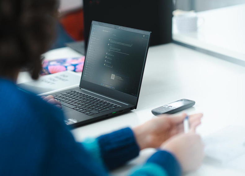 Person mit Laptop im Hintergrund