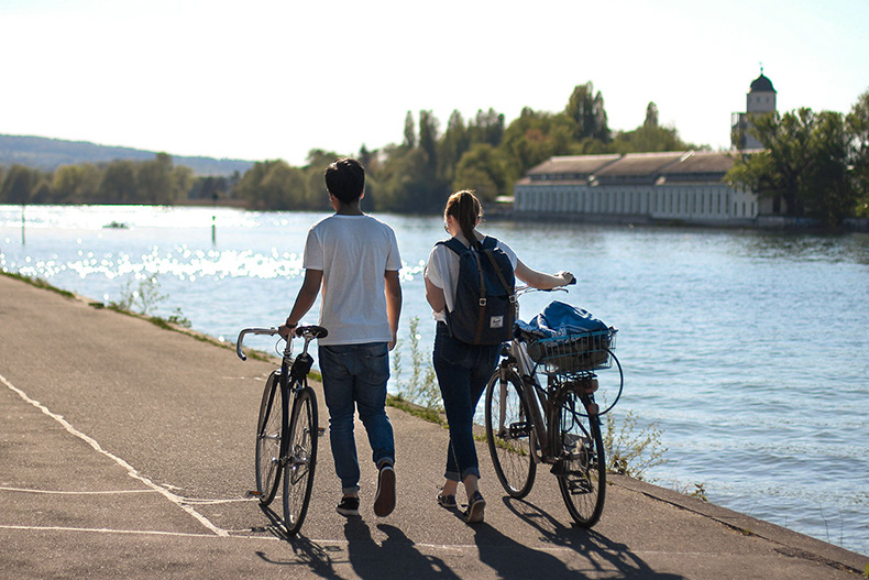 Two people pushing their bicycle