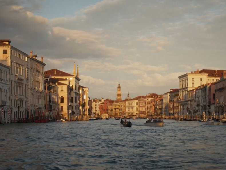 Blick über den Canal Grande in Venedig mit historischen Gebäuden, Booten und Gondeln bei Abendlicht. Das Bild steht exemplarisch für die Ausstellung „Der Klang Venedigs“, die die akustische Identität der Lagunenstadt erforscht.