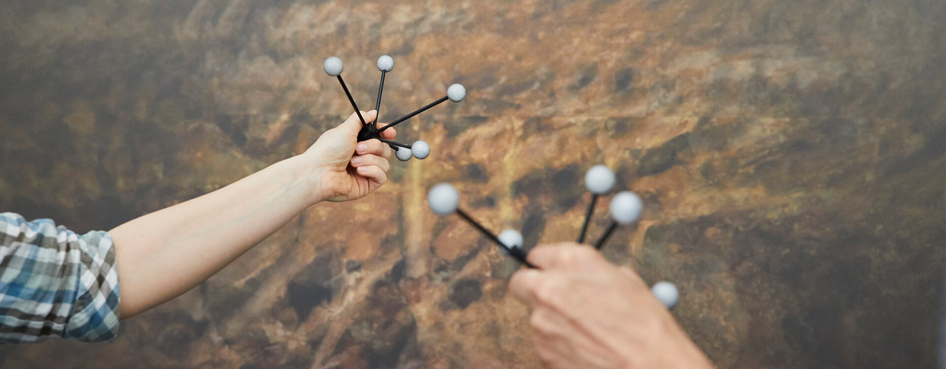 Molekülmodelle werden von zwei Händen hochgelalten