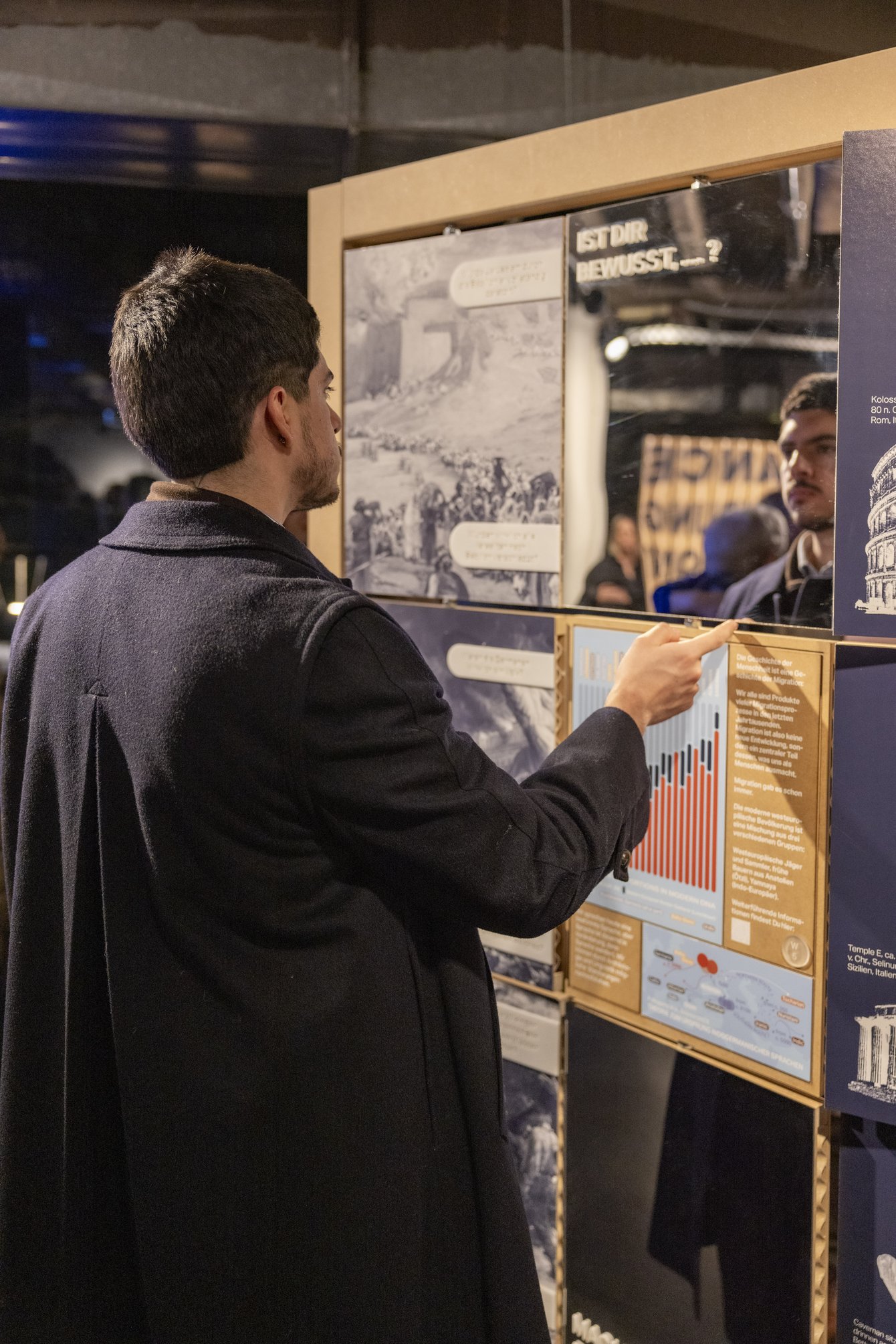 Besucher erkundet interaktive Ausstellung zum Thema Migration.