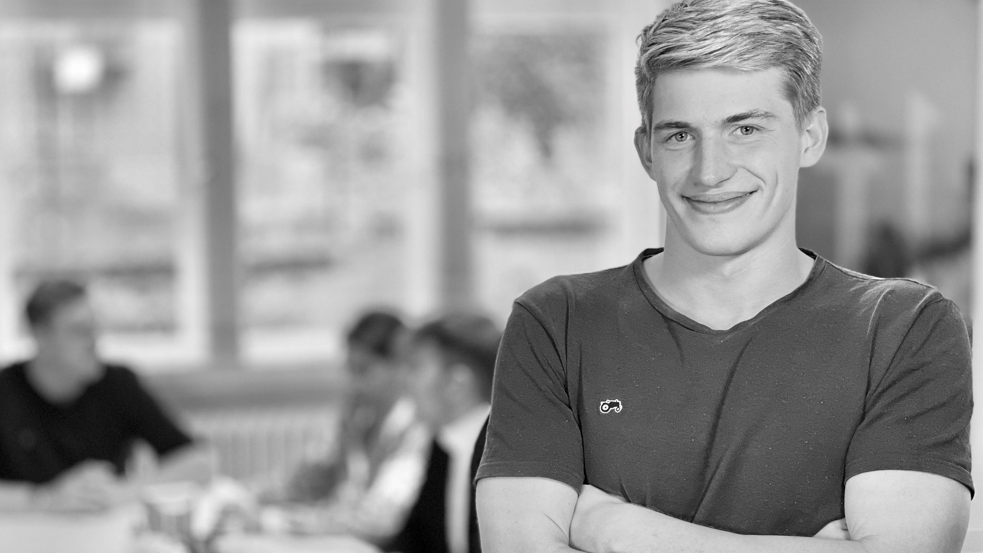 IT Management Studium: Entschlossener junger Mann steht vor Tisch