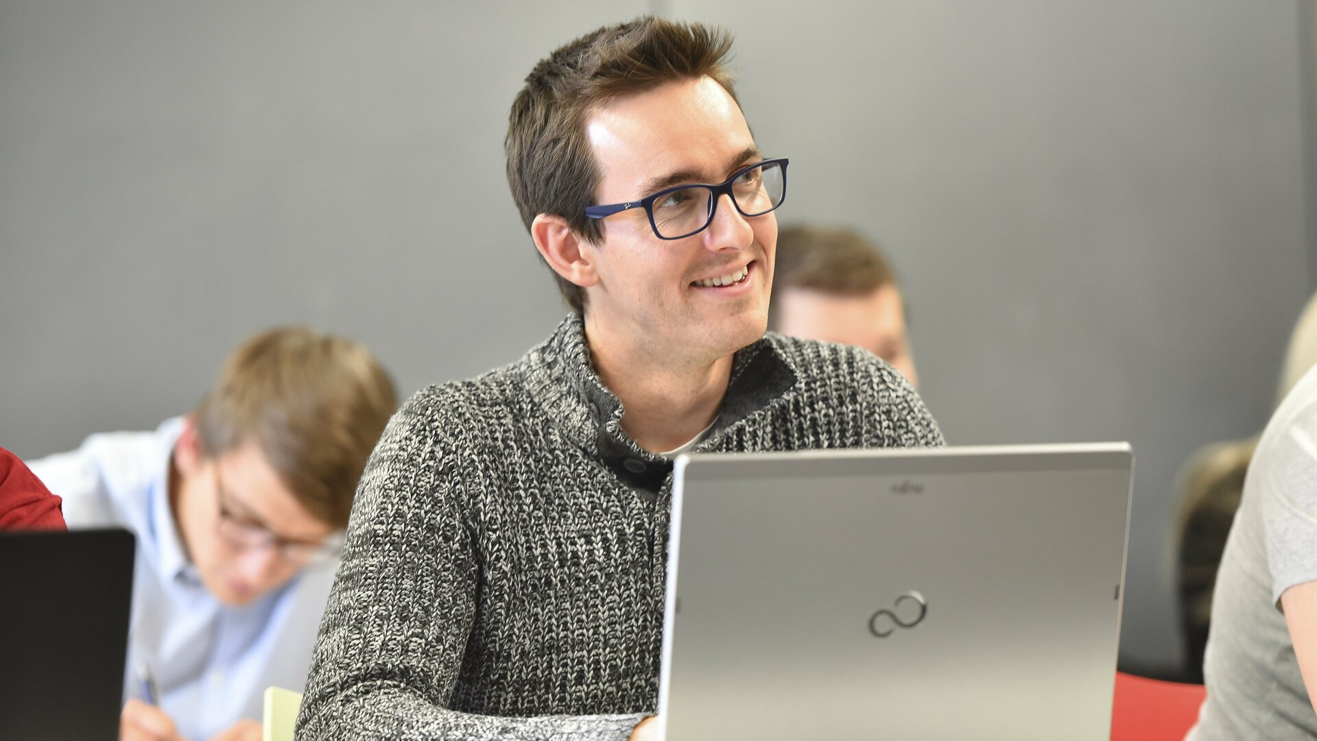 IT Management Studium: Mann am Laptop in einer Vorlesung 