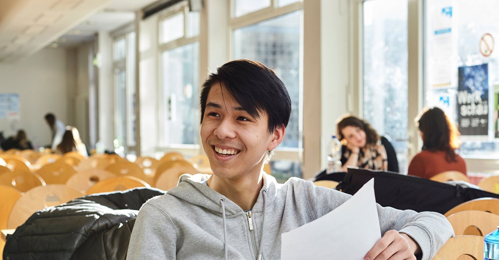 Studierender sitz in der Mensa an der Holzstraße vor einem Laptop