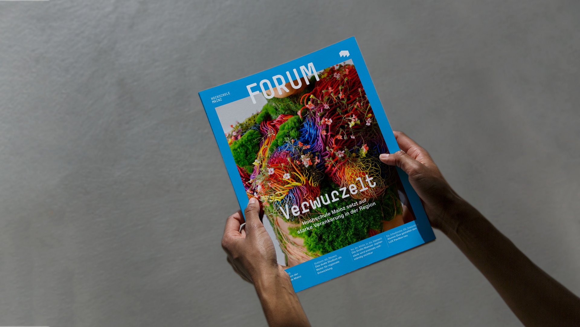 Cover des Hochschulmagazins FORUM der Hochschule Mainz, gehalten von zwei Händen.